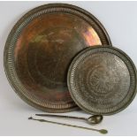 Two large copper middle Eastern chargers, the largest signed to reverse, diameter 58cm, plus a