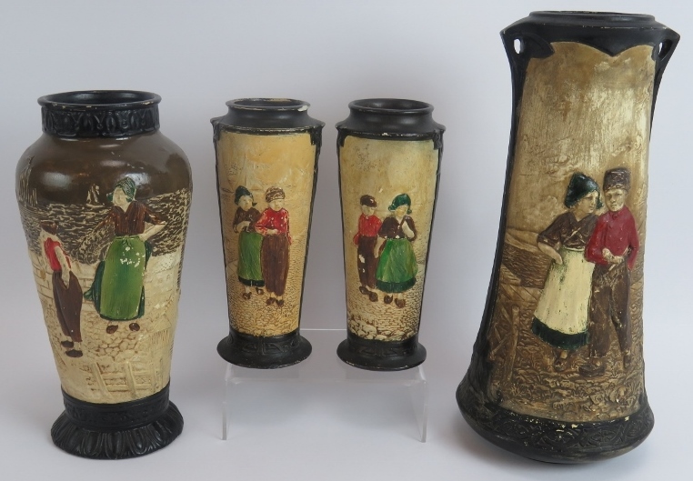 Four Bretby pottery vases each hand decorated over relief traditional Dutch scenes. Tallest 32.