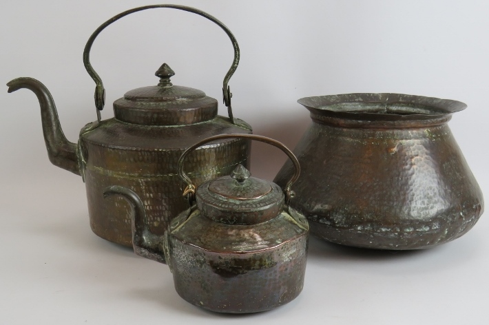 Two beaten copper Omani kettles, largest 36cm tall and a similar beaten copper cooking pot, 32cm