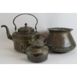 Two beaten copper Omani kettles, largest 36cm tall and a similar beaten copper cooking pot, 32cm