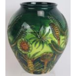 A Moorcroft pottery vase c1997 decorated with tropical plants, signed to base. Height 22cm.