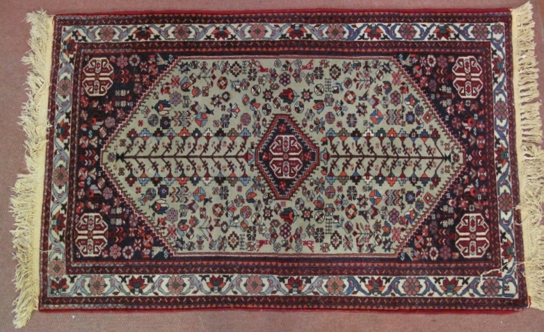 A Persian rug, 20th century, decorated with a central lozenge medallion amidst stylised motifs and