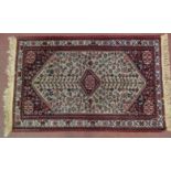 A Persian rug, 20th century, decorated with a central lozenge medallion amidst stylised motifs and
