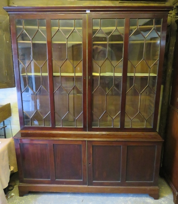 A George III Cuban mahogany tall glazed bookcase, the astral glazed doors opening onto three