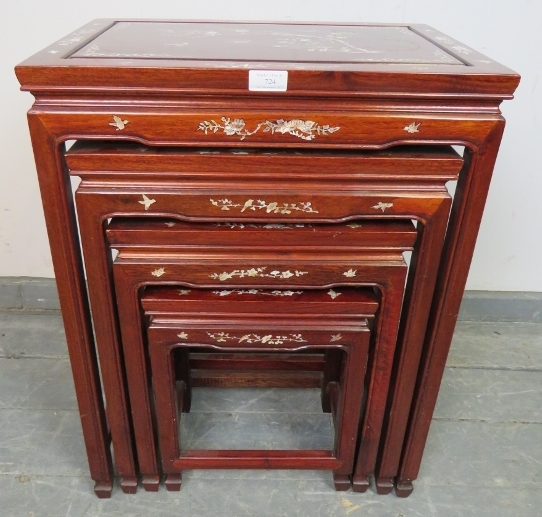 A vintage Chinese hardwood quartetto of nesting tables, featuring mother of pearl inlay depicting