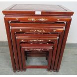 A vintage Chinese hardwood quartetto of nesting tables, featuring mother of pearl inlay depicting