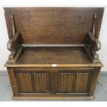 An antique oak monk’s bench, with metamorphic backrest and carved arms in the form of lions, over