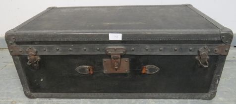 An antique travelling trunk by Malles Goyard of Paris, bound with leather strapwork and brass studs,