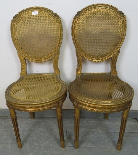 A pair of vintage French giltwood opera seats with bergère back and seat panels, featuring carved