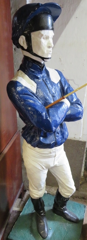 A life-size painted plaster figure of a jockey in racing colours, with riding crop, on a plinth - Image 4 of 5