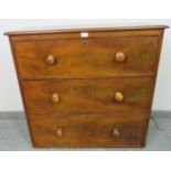 A Victorian mahogany chest of three long cock-beaded drawers with the original turned wooden knob