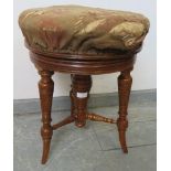 A 19th century height adjustable oak music stool, on spiral carved tapering supports united by