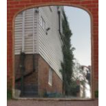 A very large 19th century arched overmantle mirror, retaining the original mercury glass plate, in a