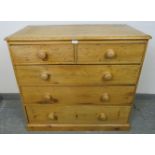 A Victorian stripped pine chest of two short over three long graduated drawers with turned wooden