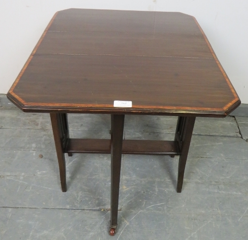 An Edwardian mahogany Sutherland table, with crossbanded inlay, on square supports with ceramic