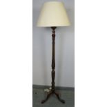 A vintage mahogany standard lamp, with carved and fluted column in the Regency taste, on a tripod