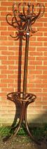 A vintage bentwood hall stand with six hat and coat hooks and umbrella rack below, on splayed