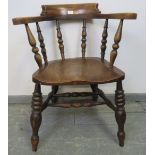 A 19th century elm and oak smokers bow chair, on turned canted supports united by a waisted