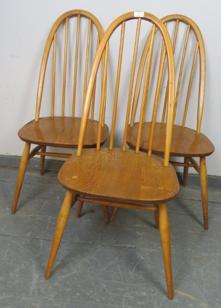 Three mid-century blond elm and beech Windsor Quaker dining chairs by Ercol, on canted supports with
