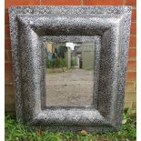 A contemporary bevelled wall mirror in an intricately tooled metal surround. Condition report: No