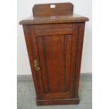 An Edwardian mahogany bedside cabinet with panelled door and loose internal shelf, on a plinth base.