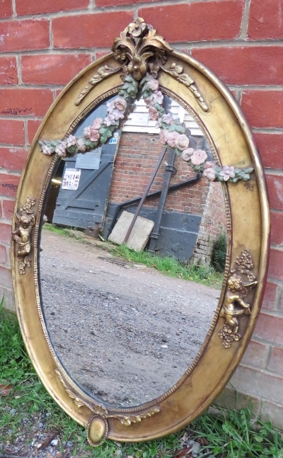 A 19th century oval wall mirror in an ornate gilt gesso frame featuring polychrome decoration in the - Image 2 of 4