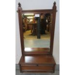 An Edwardian mahogany wall mirror with reeded detail and turned finials, above a box base with