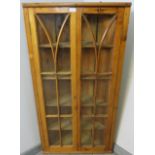 An antique pitch pine hanging corner cupboard, the astral glazed doors opening onto four fitted