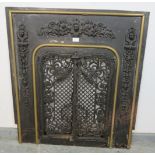 An antique cast iron and brass fireplace insert, the applied decoration depicting scrolling acanthus