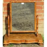A large Victorian walnut swing vanity mirror, on a shaped-front plinth base with bun feet. Condition