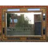 A large 19th century Napoleon III ebonised cushion mirror, the sectioned bevelled glass featuring