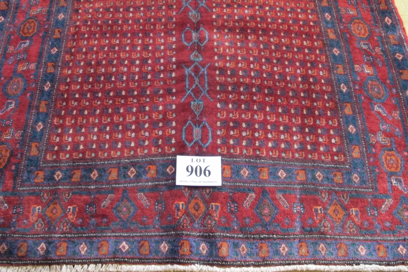North West Persian Senneh rug, central repeat pattern divided by blue motif on burgundy ground, very