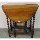 An antique oak oval gateleg table of small proportions, on barley twist supports with stretchers.
