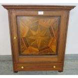 A vintage wall hanging cabinet, the panelled door featuring starburst parquetry inlay with one
