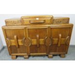 An Art Deco medium oak sideboard, with central drawer flanked by lidded compartments, above three