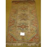 A late 20th century wool rug. Pastel shades. 135cm x 82cm. In good condition.