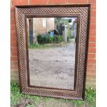 A contemporary bevelled wall mirror in an intricately tooled metal surround. Condition report: No
