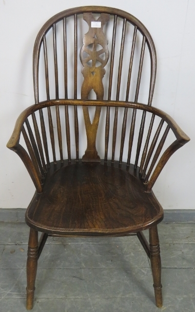 A Georgian elm wheelback Windsor armchair, on turned supports with an ‘H’ stretcher. Condition