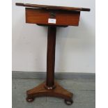 A Victorian walnut pedestal work table, the rising lid opening onto a loose tray with divided