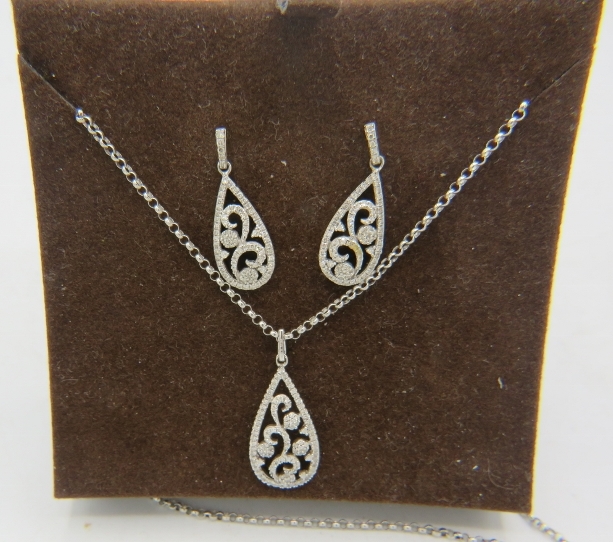 A fine pear shaped 9ct white gold pendant with openwork floral design encrusted with diamonds on a