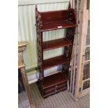 A reproduction mahogany coloured slender set of shelves with pierced sides and two lower drawers