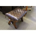 A WOVEN LEATHER TOPPED RECTANGULAR STOOL on pegged plank supports