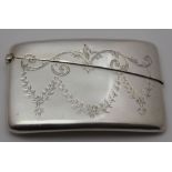 An early 20th century silver card case of curved pocket form, engraved with swags, 8.5cm x 5.5cm,