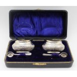 A cased pair of Edwardian silver salts, oval fluted form, Birmingham 1904, with blue glass liners
