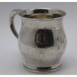 An early 20th century silver mug of baluster form, remains of gilded interior, monogrammed,
