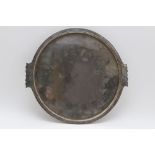 An Arts & Crafts planished silver plated copper tray, circular with shaped side handles, stamped '