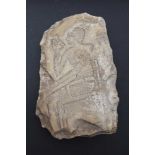 An Egyptian limestone fragment, relief carved with a seated figure, considered to be possibly