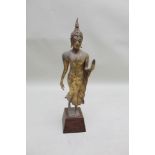 A gilt finished cast metal figure of an enlightened follower of Budda, later mounted to wooden