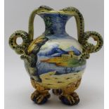 A 19th century Italian Majolica vase of flask form with serpent handles raised on four claw feet,