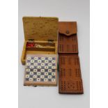 A small blonde wood box opening to reveal a miniature chess set, with a full complement of turned
